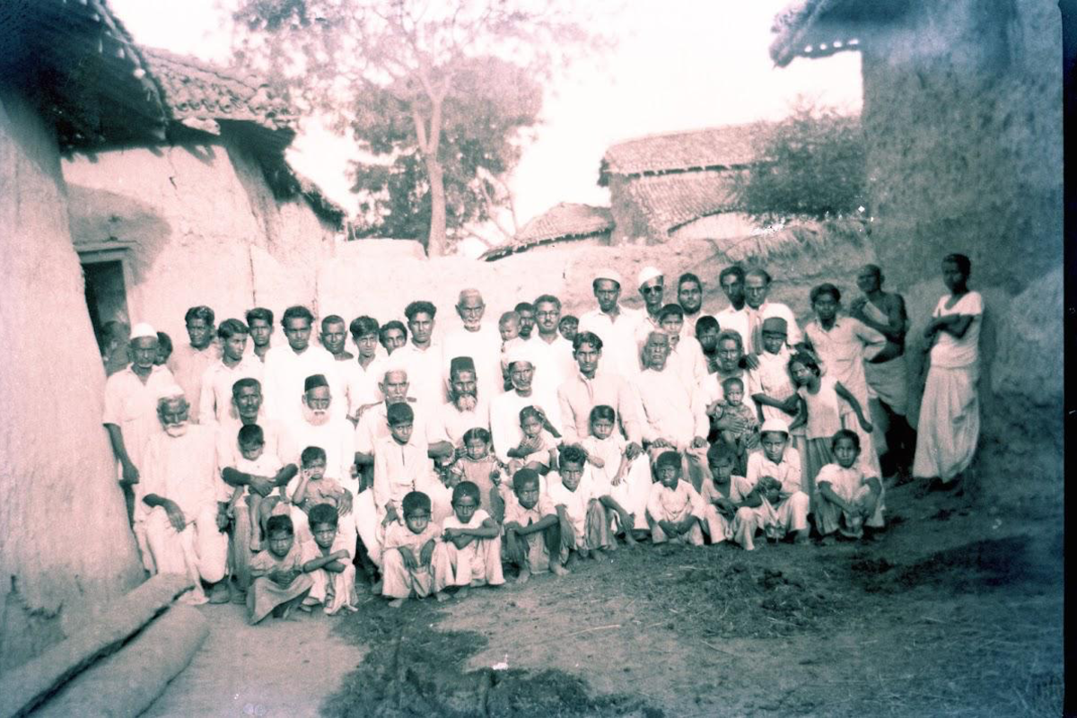 Enam's village and extended family gathered outdoors in rural India.